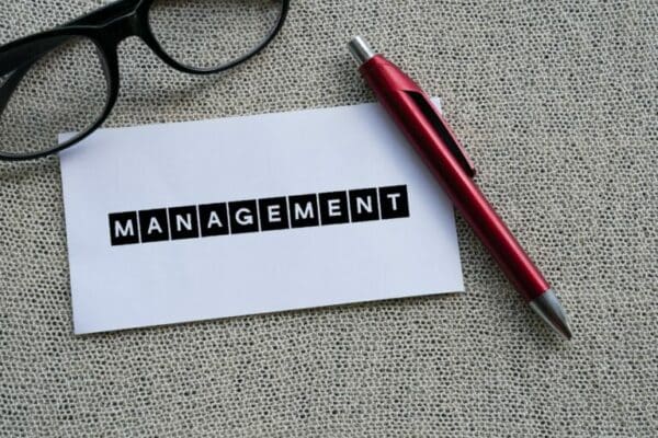The word MANAGEMENT on white paper with a red pen