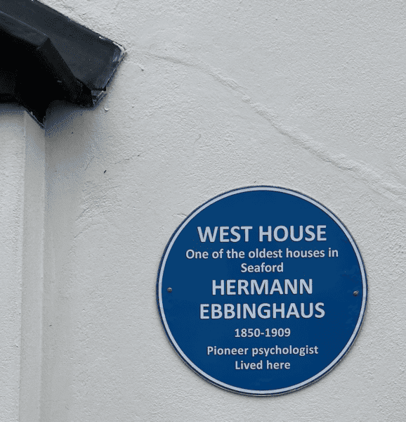 Circular Blue sign on a wall with West House oldest house in Seaford Hermann Ebbinghaus lived here