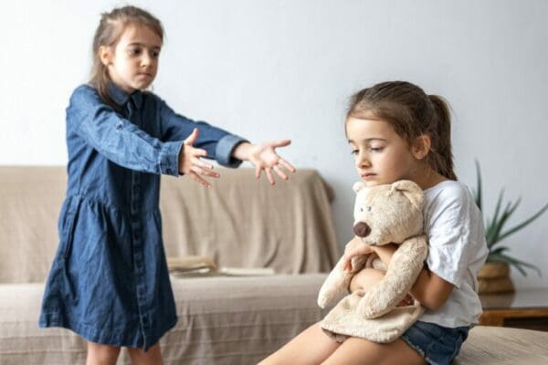 Girl sibings using persuasive language example word fair to play with toy bear