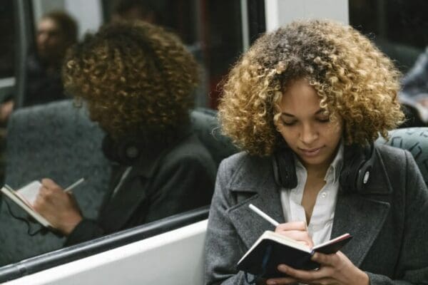 Woman taking notes on a subway and using the betari box model