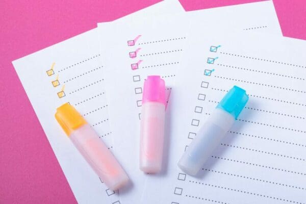 Check list with pink, blue and orange marked points and markers on pink background