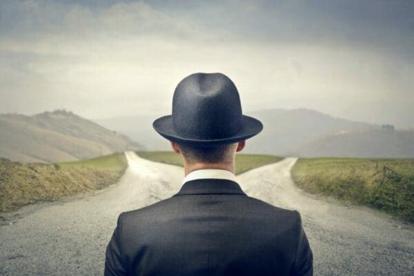 businessman in the middle of a crossroad about to choose direction
