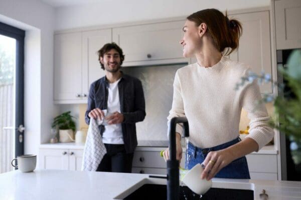 Couple at home In the kitchen with Woman cleaning mug