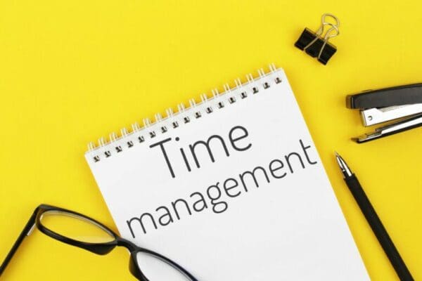 notebook with word time management on a yellow background