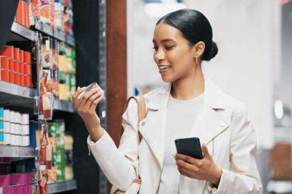 Female shopper looking at item from supermarket shelf