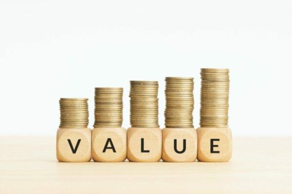 Value on wooden blocks and rising stacked coins