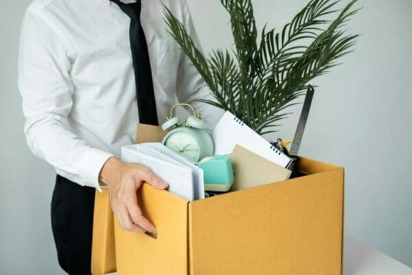 Business man employee during resignation from job while picking up personal belongings in a box