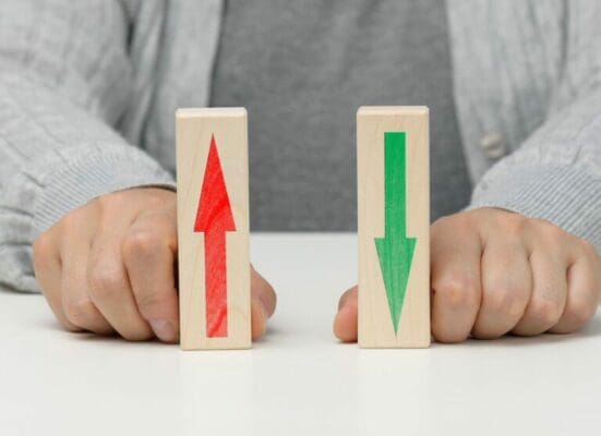 Female hand holds wooden blocks with up and down arrows