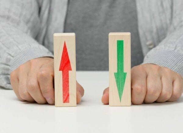 Female hand holds wooden blocks with up and down arrows