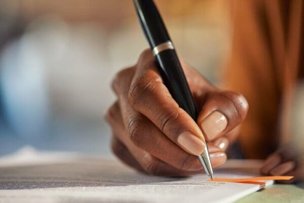 Close up of black woman hand writing a report