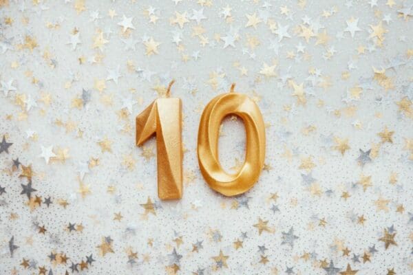 Number 10 ten golden celebration birthday candle on Festive Background
