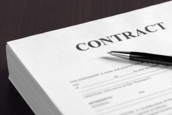 Coaching Contract document with pen on top