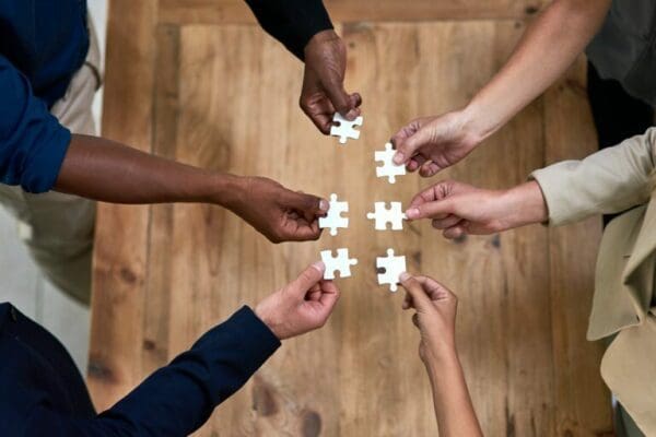 Hands of diverse people putting a puzzle together
