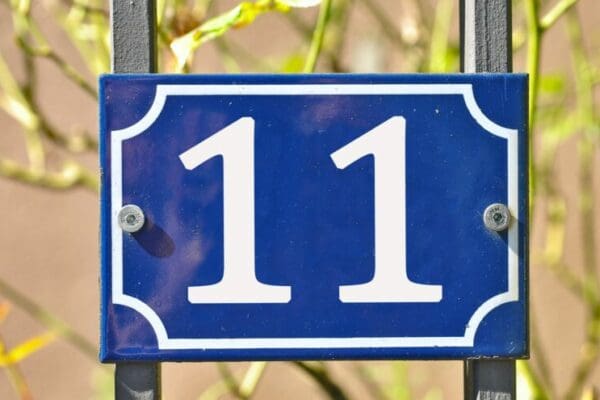 Closeup shot of a blue sign with the number 11 on the blurry background