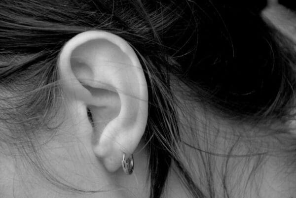 Greyscale closeup of an ear with earring