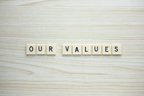 Our Values letter tiles on a wood grain background
