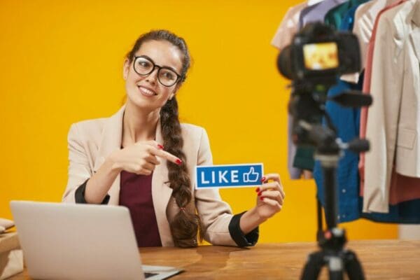 Businesswoman holding up a blue Social media like icon sign for likability